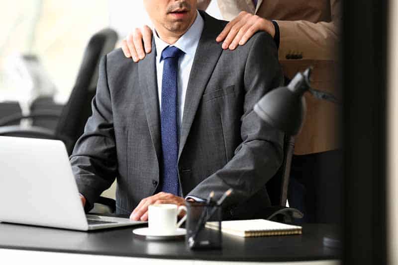 Man harassing his male colleague in office Man harassing his male colleague in office