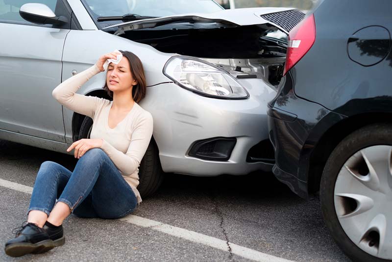 skilled Fresno car accident attorneys Woman holding her head after a car collision