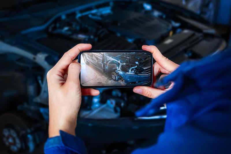 man taking picture of a wrecked car