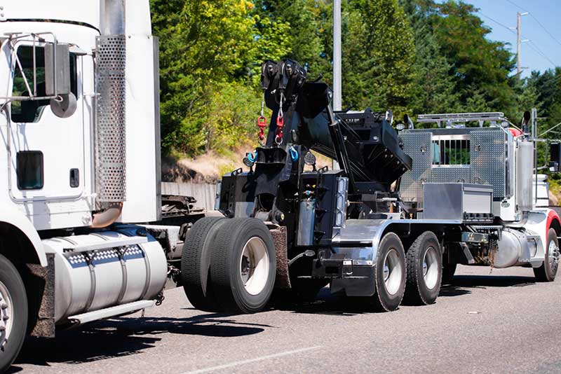 white big rig being towed