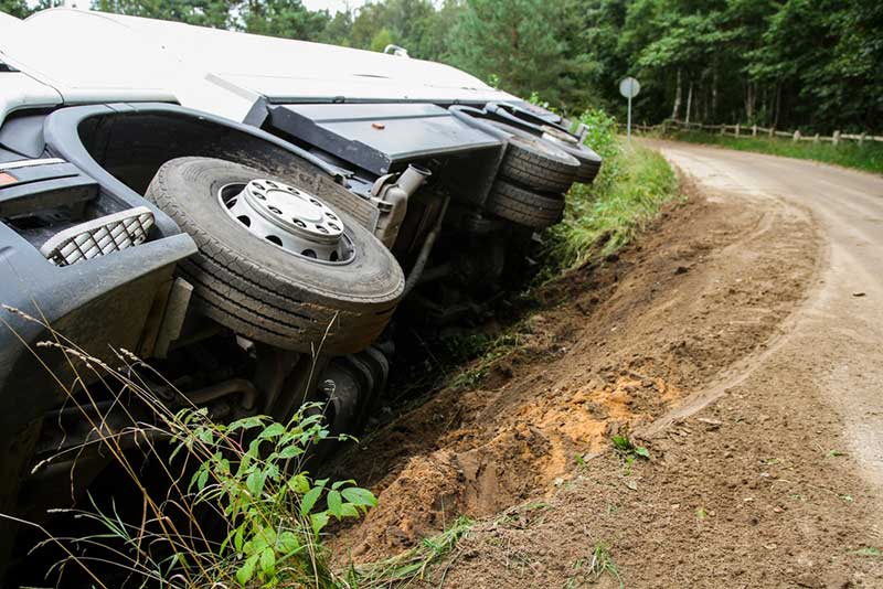 big rig tipped over at the side of the road